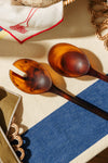 Two tortoiseshell spoons on a textured surface with a blue and beige pattern. Maegen | Shop Fodder
