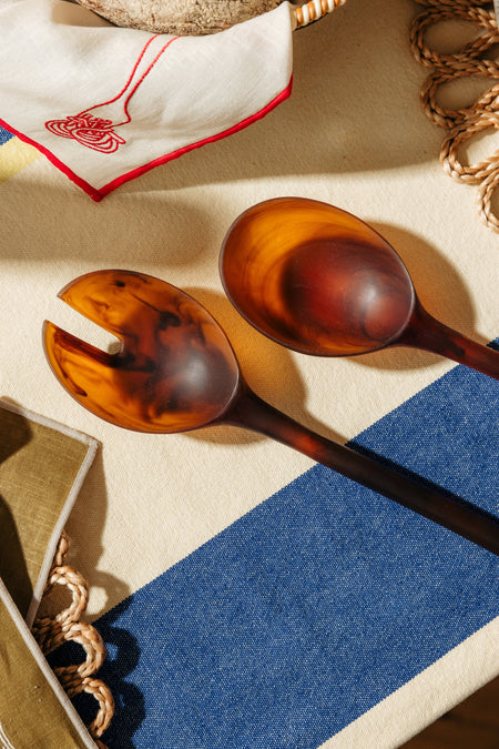 Two tortoiseshell spoons on a textured surface with a blue and beige pattern. Maegen | Shop Fodder