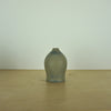 a small blue grey coloured handmade ceramic vase on a table. 