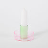 pink and green candlestick holder on white background. 