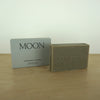 a bar of soap and a box on a wooden table by Evermove London. 