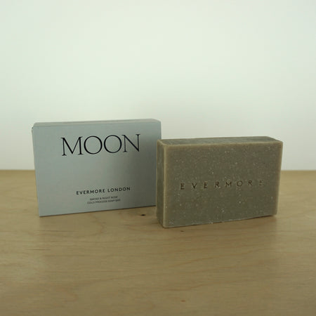 a bar of soap and a box on a wooden table by Evermove London. 