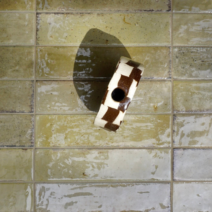 Checkered object on a tiled wall