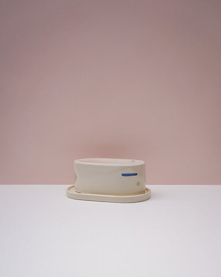 White ceramic butter dish with saucer on a light pink background. Brutes Ceramics | Inlay Butter Dish | Fodder