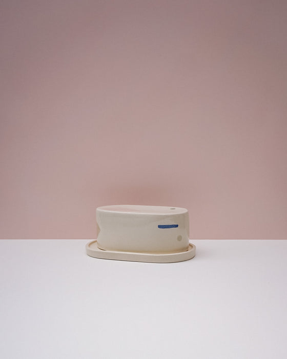 White ceramic butter dish with saucer on a light pink background. Brutes Ceramics | Inlay Butter Dish | Fodder
