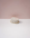 Round white object on a white surface with a pink background . Brutes Ceramics | Inlay Butter Dish | Fodder
