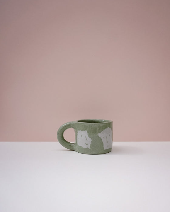 Green ceramic mug with white text on a pink background. Portrait Mug | Brutes London | Handmade Ceramics | Fodder