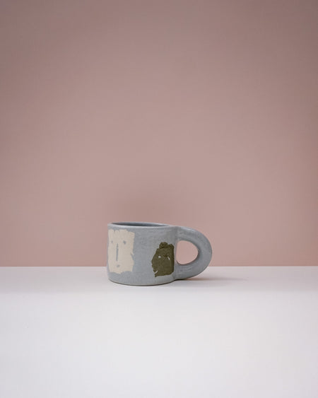Blue mug with a face design on a pink background. Portrait Mug | Brutes London | Handmade Ceramics | Fodder