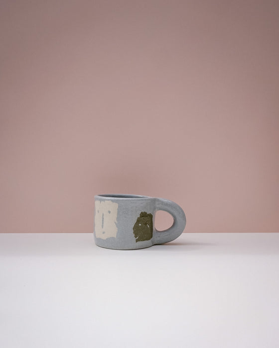 Blue mug with a face design on a pink background. Portrait Mug | Brutes London | Handmade Ceramics | Fodder