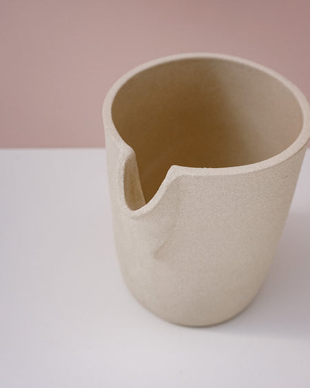Beige ceramic cup on a white surface with a pink background. Handmade Stoneware 500ml Carafe by BRUTES Ceramics | Shop Fodder