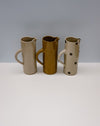 Three ceramic pitchers with different designs on a white surface and gray background - Water jug by Cara Guthrie - handmade stoneware - Fodder
