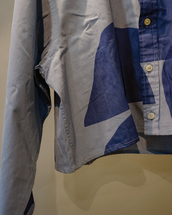 A close-up of a long-sleeve button-up shirt with an abstract geometric pattern in shades of blue, navy, and light gray, featuring light-colored buttons. Caroline Dickinson Shirt | Fodder