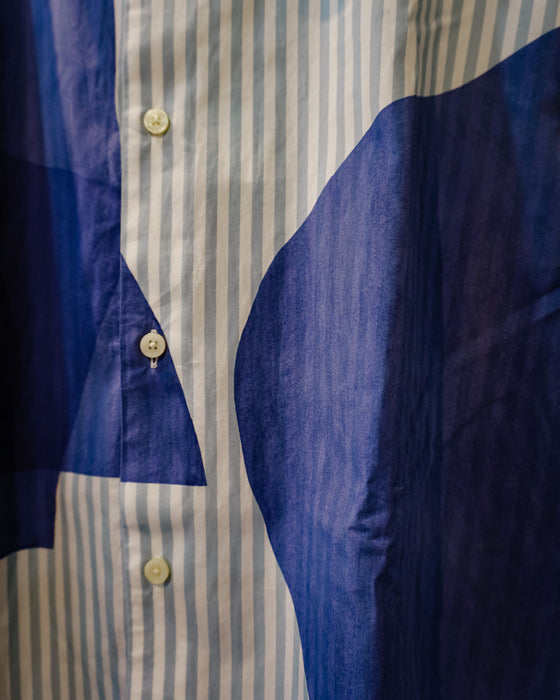 Close-up of a button-front shirt with vertical light stripes on one side and large solid dark blue fabric panels on the other, with cream buttons. Caroline Dickinson Shirt | Fodder