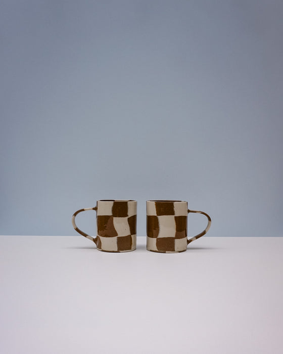 Two ceramic mugs with a checkered pattern on a light gray background. Checkerboard Nerikomi Ceramic Mug | Fern Taylor | Kentish Town Stores