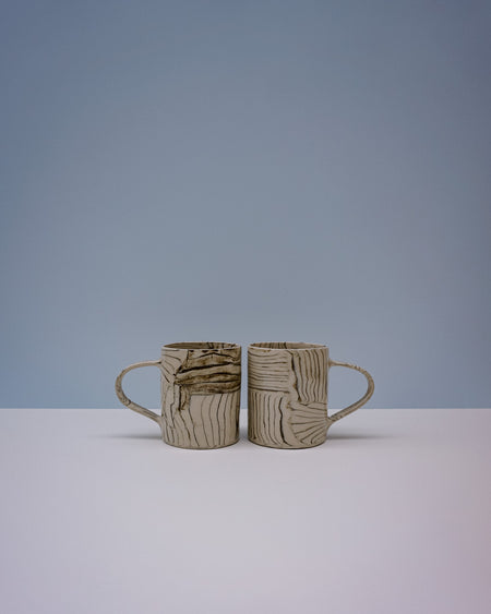 Two ceramic mugs with textured surfaces on a light grey background. Grain Nerikomi Ceramic Mug | Fern Taylor | Kentish Town Stores