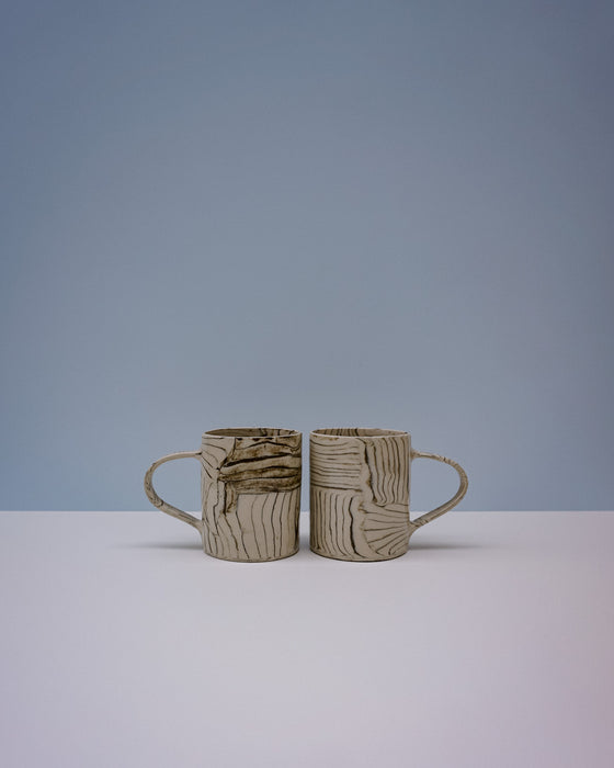 Two ceramic mugs with textured surfaces on a light grey background. Grain Nerikomi Ceramic Mug | Fern Taylor | Kentish Town Stores