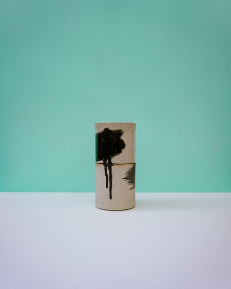 Two cylindrical containers with black abstract designs on a light blue background.  Janne Meijer Ceramics | Shop Fodder