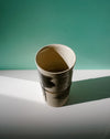Ceramic cup on a white surface with a green background. Janne Meijer Ceramics | Shop Fodder