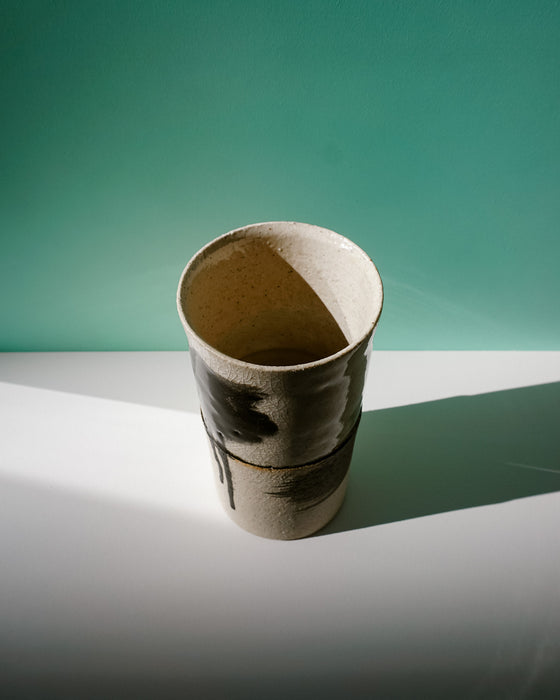 Ceramic cup on a white surface with a green background. Janne Meijer Ceramics | Shop Fodder