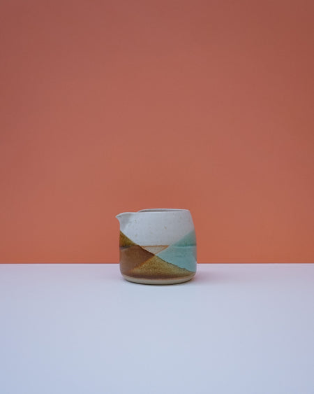 Ceramic pitcher with geometric design on a peach background. Liz Vidal Ceramics | Shop Fodder