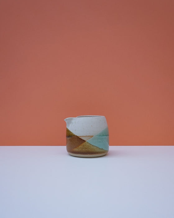 Ceramic pitcher with geometric design on a peach background. Liz Vidal Ceramics | Shop Fodder