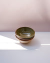 Three stacked ceramic bowls with a speckled green glaze and a speckled beige exterior, set on a white surface against a soft pink background. Morning Bowl | Scree Ceramics | Fodder