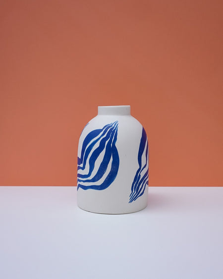 White vase with blue abstract patterns on a peach background. Sophie Alda | Handmade Ceramics | Shop Fodder