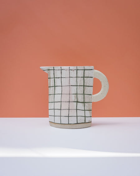 Ceramic pitcher with grid pattern on a peach and white background. Sophie Alda | Handmade Ceramics | Shop Fodder