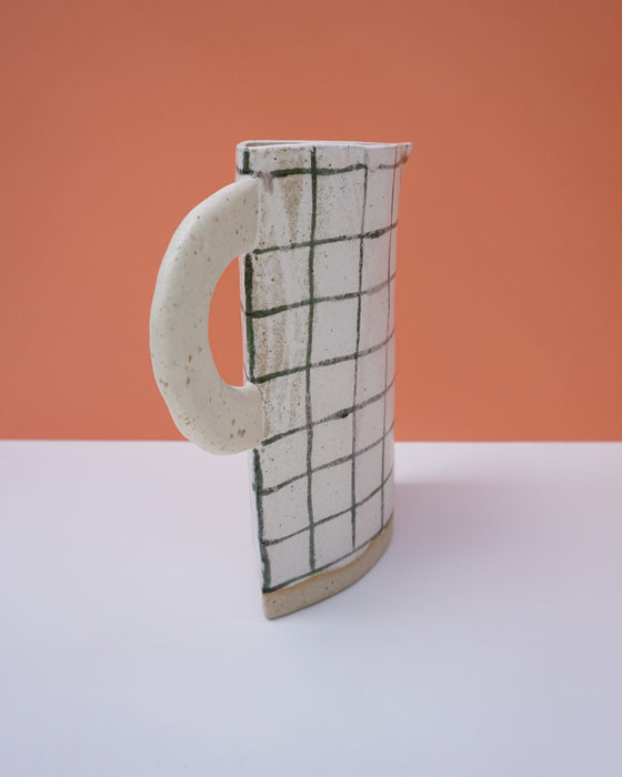 Ceramic mug with grid pattern on an orange and white background. Sophie Alda | Handmade Ceramics | Shop Fodder