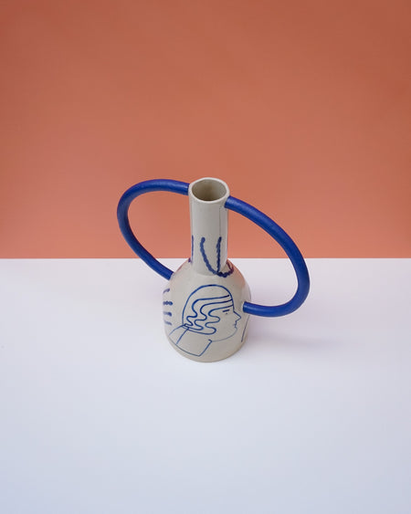 Ceramic vase with blue accents on a white surface against an orange background. Sophie Alda | Handmade Ceramics | Shop Fodder