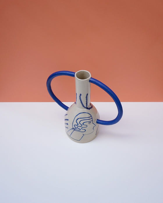 Ceramic vase with blue accents on a white surface against an orange background. Sophie Alda | Handmade Ceramics | Shop Fodder
