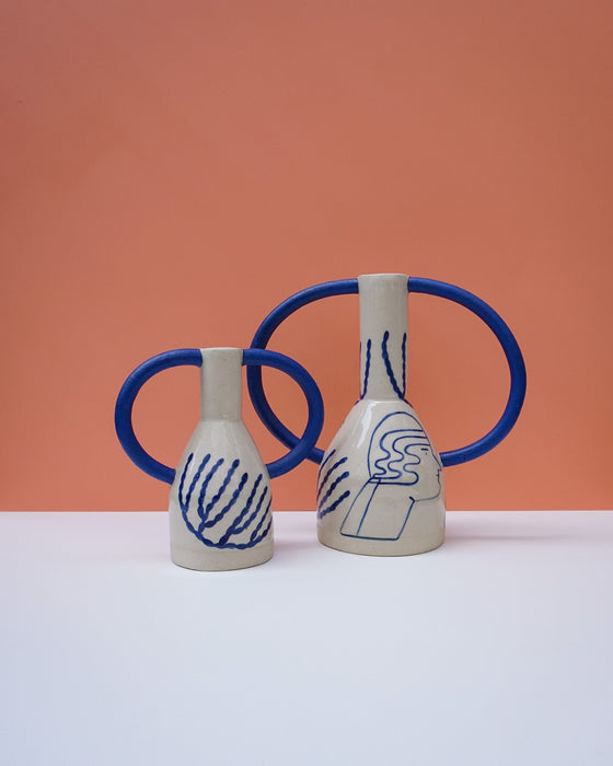 Two ceramic vases with blue handles and abstract designs on a peach background. Sophie Alda | Handmade Ceramics | Shop Fodder