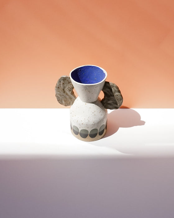 Ceramic vase with blue interior and textured surface on a peach and white background. Sophie Alda | Handmade Ceramics | Shop Fodder