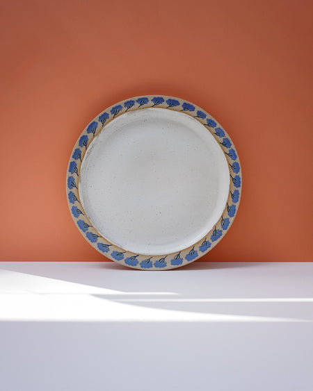 White ceramic plate with blue floral rim on an orange background. Sophie Alda | Handmade Ceramics | Shop Fodder