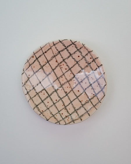 Round ceramic plate with grid pattern on a light gray background. Diddy Bowl | Jode Pankhurst | Shop Fodder