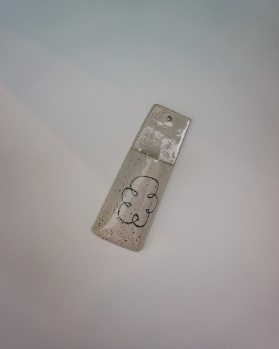 Small rectangular metal object with a cloud design on a light gray background | Jode Pankhurst