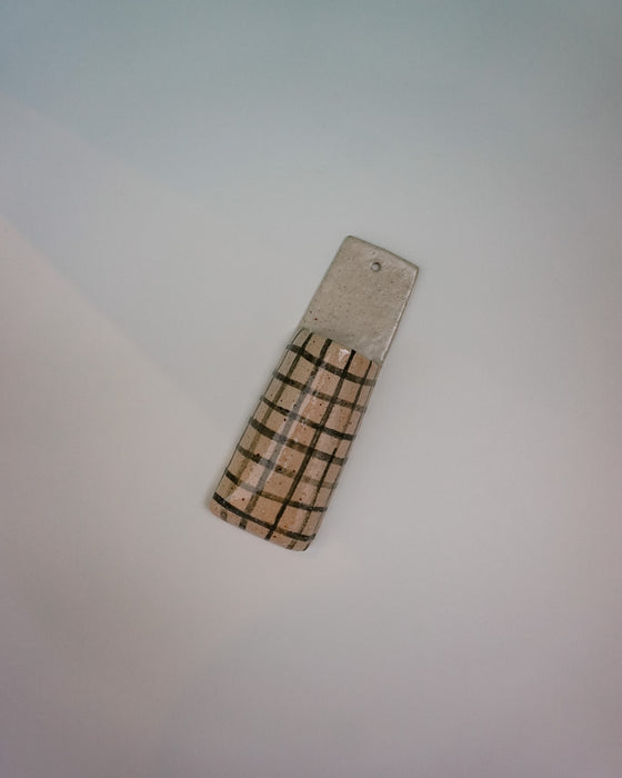 Cylindrical object with checkered pattern on a light gray background | Jode Pankhurst