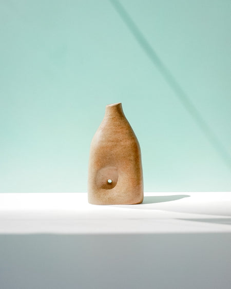 Wooden vase on a white surface with a light blue background | Jode Pankhurst