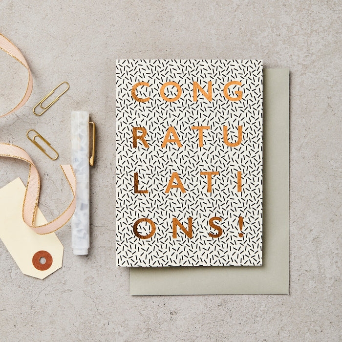 black and white card with gold letters spelling congratulations. 