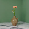 handmade ceramic bud vase in a Oat glaze with a flower. 