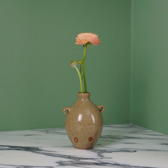 handmade ceramic bud vase in a Oat glaze with a flower. 