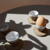 4 egg cups on a table. one has an egg in it | Lily Pearmain | Shop Fodder