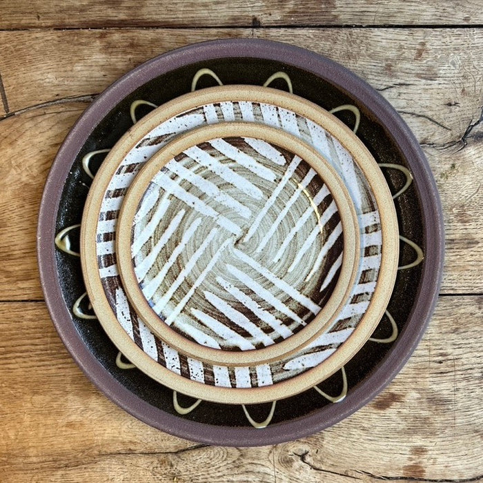 a stack of three plates on a wooden table taken from above. 