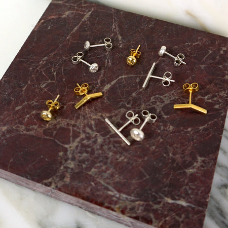 Collection of gold and silver earrings on a marbled surface | Mix & Match Studs | Scarlett French | Fodder