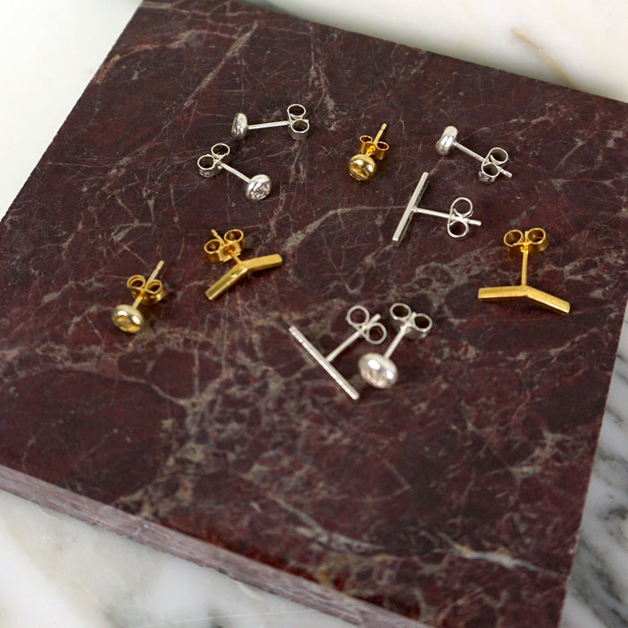 Collection of gold and silver earrings on a marbled surface | Mix & Match Studs | Scarlett French | Fodder