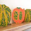 Decorative paper pumpkins with green leaf patterns on a wooden Mantelpiece. Pumpkin Handprinted Garland | East End Press | Shop Fodder