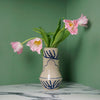 the back of a hand painted ceramic vase with a bunch of pink tulips. 