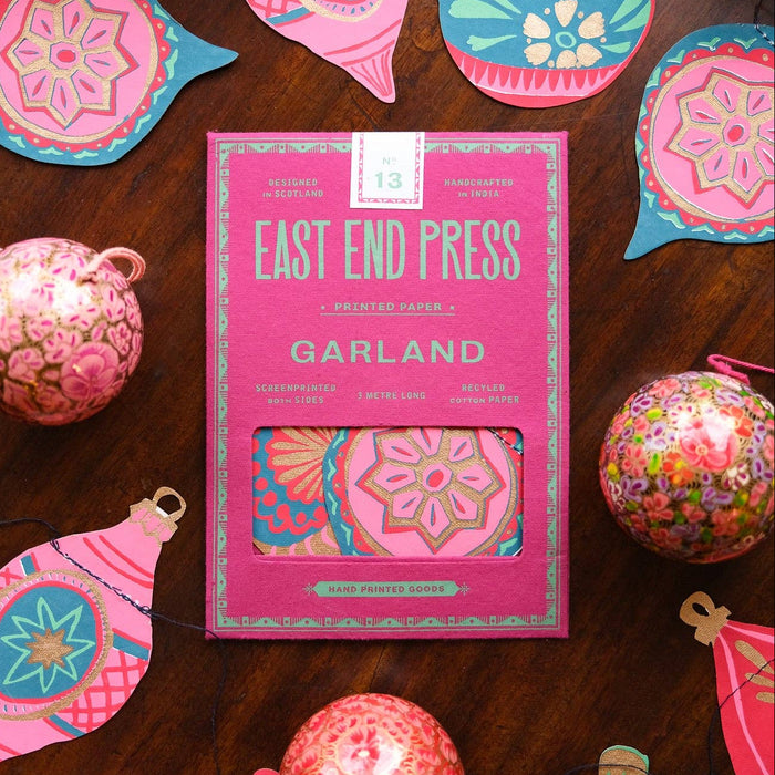 Decorative Christmas ornaments with 'East End Press' packaging on a wooden surface | East End Press | Shop Fodder