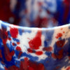 close up of a blue and red splatter glaze by anna jones ceramics. 