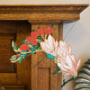 Decorative floral wall art hanging on a wooden wall. East End Press | Shop Fodder